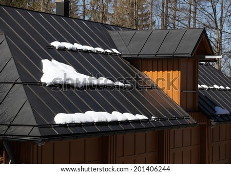 Metal roof of house with snow