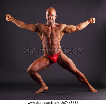 Muscular male bodybuilder posing in studio
