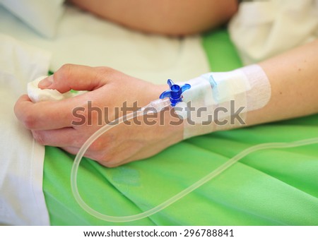 Patient hand with infusion on hospital bed