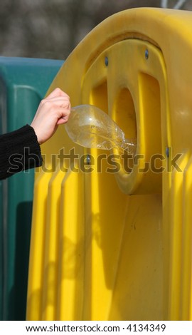 Hand throws recycling material in litter bin