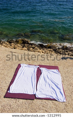 Two empty beach towels on the beach