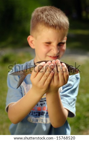 Young boy holding fish he catch