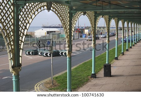 Seafront promenade at Brighton. East Sussex. England. With cafe viewed from under the arches.