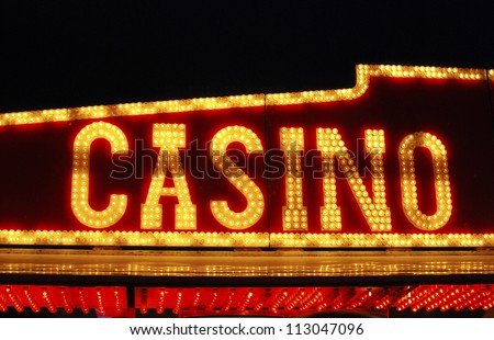 Illuminated Casino sign over fairground arcade of gaming machines. Sussex. England