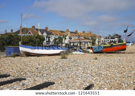 Small fishing boats on shingle beach at Worthing. West Sussex. England. With guesthouses in background.