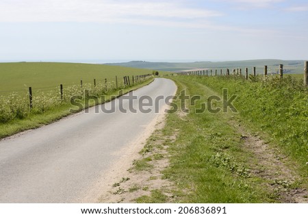Narrow country lane on South Downs near Shoreham. West Sussex. England. Looking south over coast.