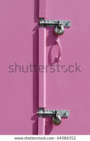 Two padlocks on pink door of beach hut. Seafront promenade at Hove. Brighton. East Sussex. England