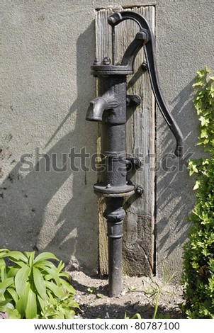 Old cast iron hand powered water pump on wall of church. Shoreham. Kent. England