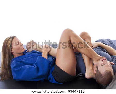 Female martial artist applying an arm-bar with foot-choke combo