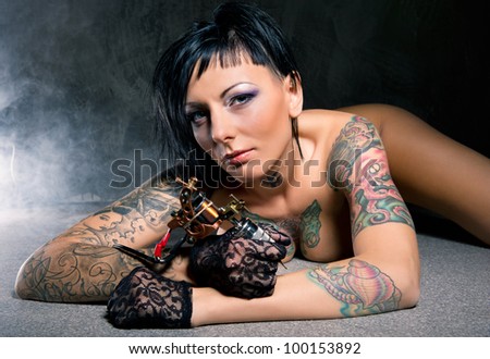 Beautiful woman with many tattoos posing indoors