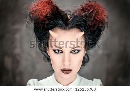 Portrait of beautiful horned woman with bright makeup, conceptual photo