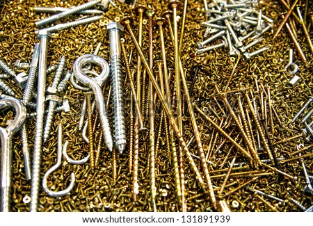 Pile of gold and silver screws, various shapes and sizes for different purposes