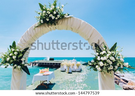 Wedding arch and wedding chairs on the empty beach