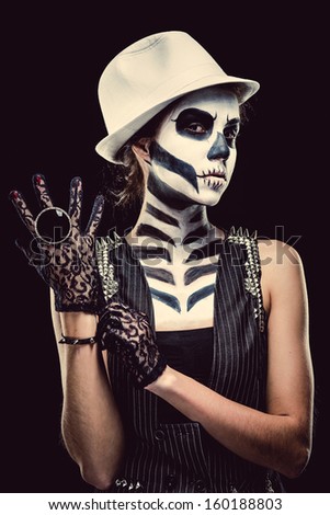 Woman with skeleton face art over black background