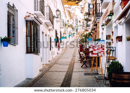 Mijas, Spain- January 05, 2014: Charming whitewashed narrow street In Mijas lined with cafes, restaurants and souvenir shops. Mijas is a lovely Andalusian white village on the Costa del Sol. Spain