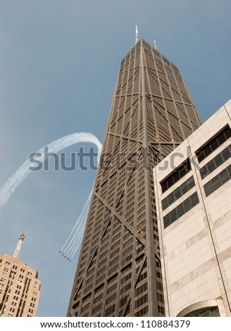 CHICAGO, IL - AUGUST 18: Aerobatic group formation during Air Show in Chicago as visible by John Hancock Building on August 18, 2012 in Chicago, IL.