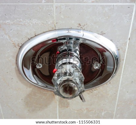 showerhead water control knob mounted on outside wall with high temperature security switch for safety.