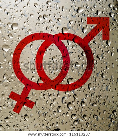 Mars Venus or Male Female symbol on surface covered with rain drops. Birth Control.