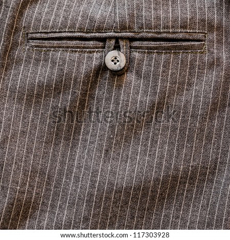 Close up of a pocket button on back of a stripped business suit Pant or trouser. HIgh Contrast.