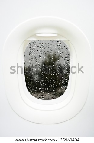 Aircraft Window with plane with rainy window and raindrops