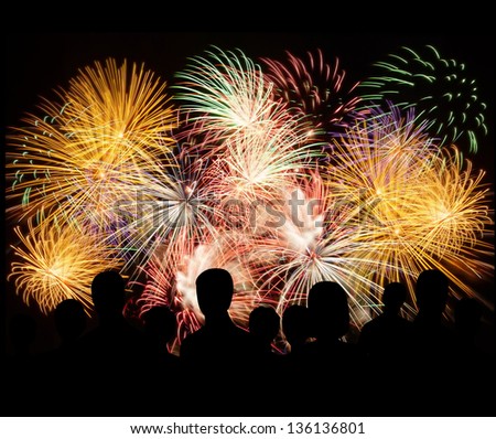 Group Of People Enjoying Spectacular Fireworks Show In A Carnival Or Holiday. People In Silhouette.