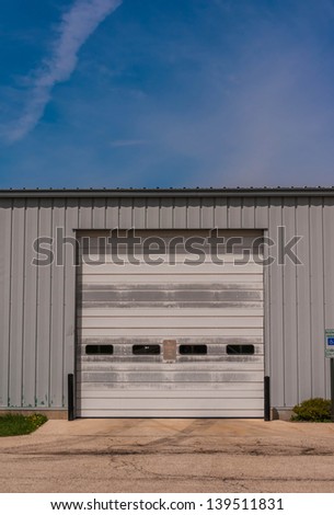 industrial warehouse with green and roller doors and handicape parking sign