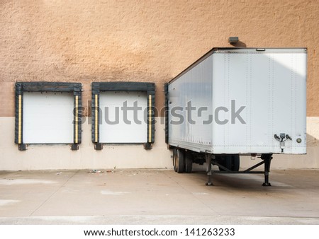 Loading docks and the semi truck trailer transferring cargo in the industrial area or for departmental store. Where is the cargo?