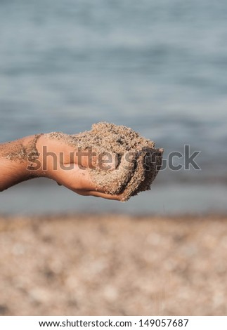 Child\'s hand holding sand