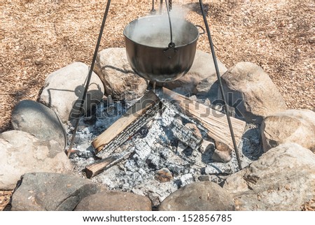 outdoor cooking scene with Cauldron on Campfire