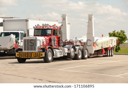 Chicago, IL June 03: Oversize load of heavy machinary on a semi flatbad truck at a rest stop on June 03, 2013.