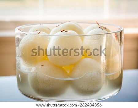 Indian sweet. Rasgulla is a syrupy dessert popular in the Indian subcontinent, and is made out of Indian cottage cheese and sugar syrup.Creative abstract lighting and selective focus