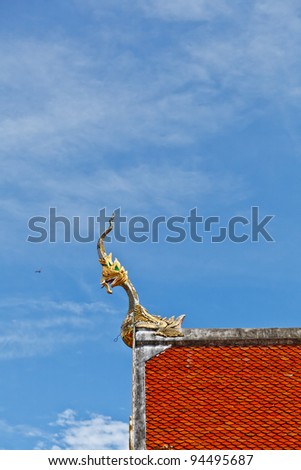 The Naga gable apex on the top roof of Pongsanuk Temple, Lampang Province, Thailand