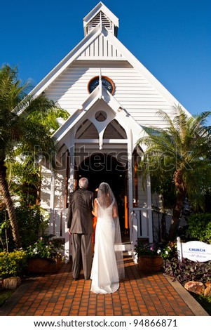 Father standing with bride outside a church, ready to give her away