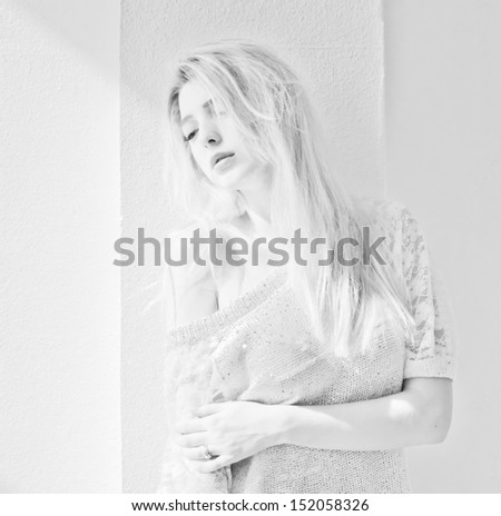 portrait of attractive girl posing against white wall.  black-and-white photo