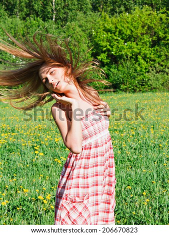 romantic beautiful young woman outdoors,  model in field long hair blowing