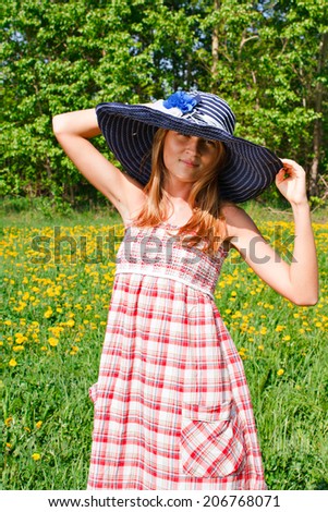Portrait of a beautiful young woman in hat outdoors