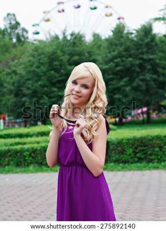 Portrait of a beautiful young woman in a violet dress in park