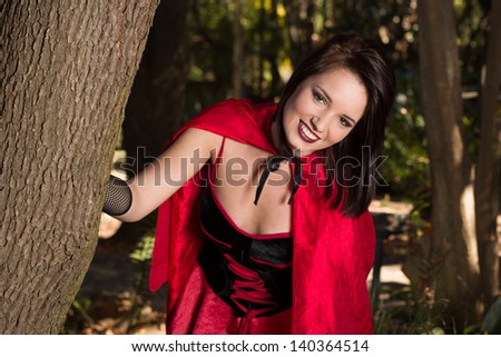 Young woman dressed up as Red riding hood in the woods