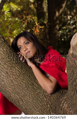 Adult woman dressed up in Red riding hood costume in the woods