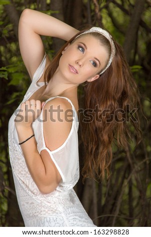 Casually dressed young girl with long hair posing in the bush