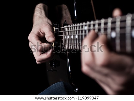 Human hand playing an electric guitar