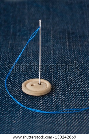 Needle with wooden buttons on denim