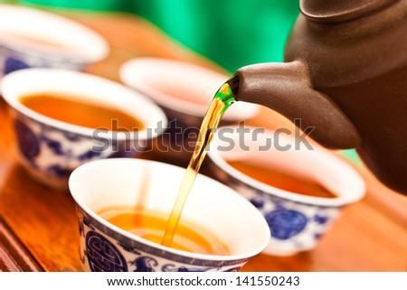 Tea is poured into the cup closeup