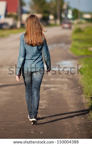 The back is a girl walking down the village street