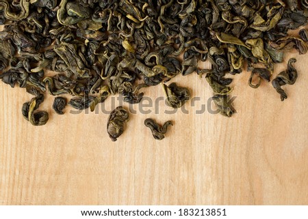 Green tea spilled on a wooden surface