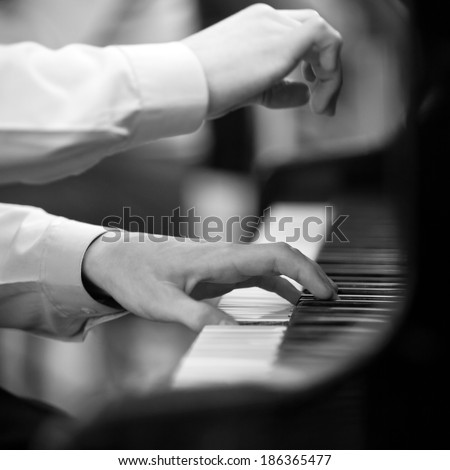 Hands pianist playing on a grand piano in black and white