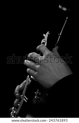 Human hand plays the clarinet closeup in black and white