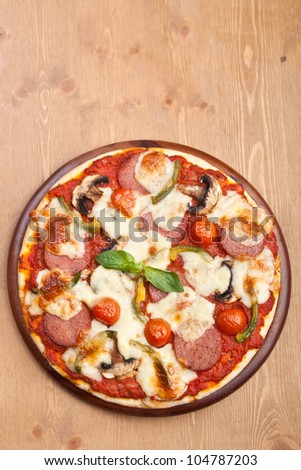 salami, mushroom and vegetable pizza with ingredients on cutting board