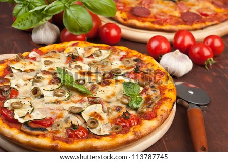 Super healthy vegetables and mushrooms pizza and salami pizza at the back
