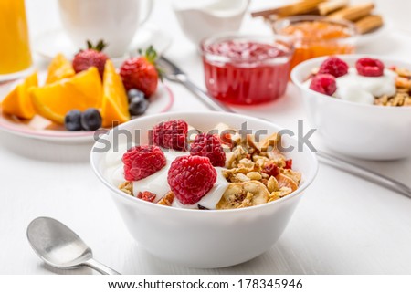 Healthy Breakfast Meal - Bowl of Fruit, Oat and Nut Granola  with Yogurt and Raspberries